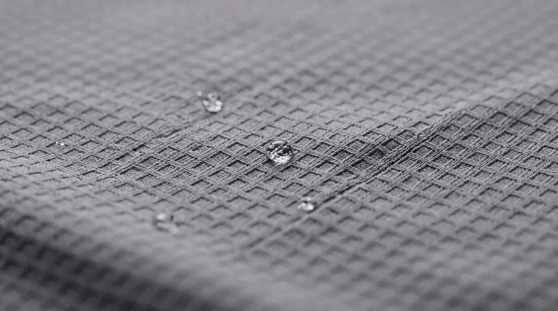 Water beading on grey textured polyester fabric