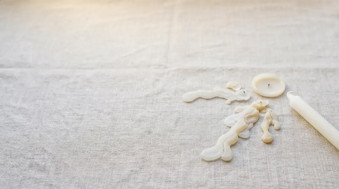 Dripped candle wax from a taper candle on linen