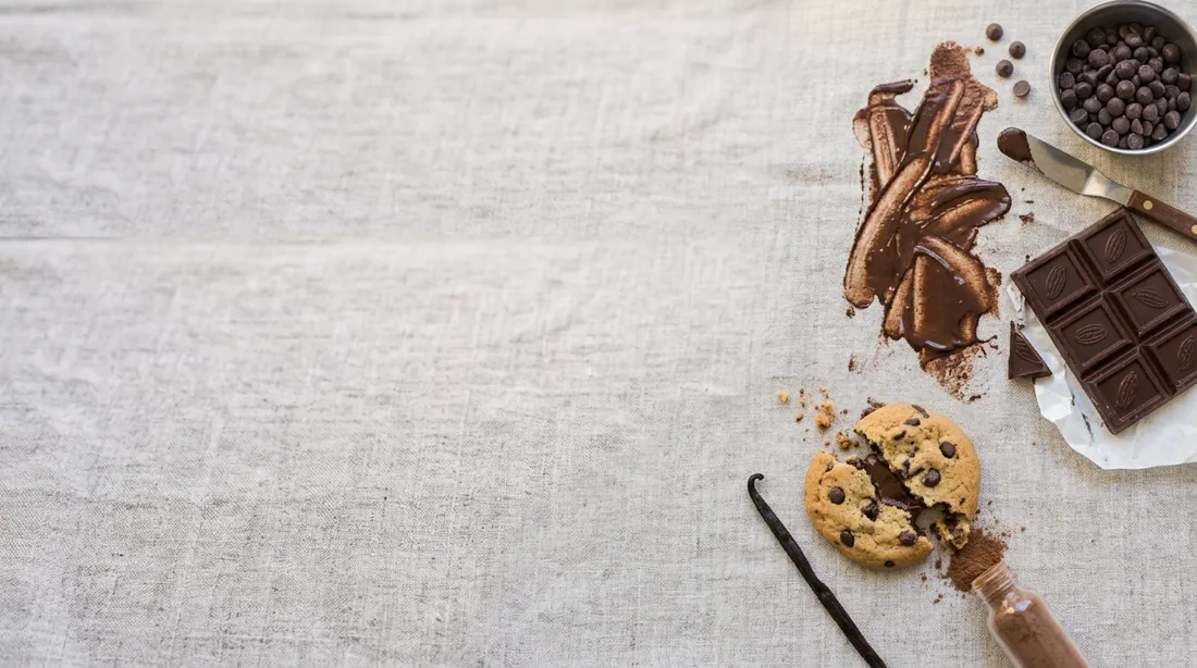 Melted chocolate smears with a chocolate bar and a cookie on linen