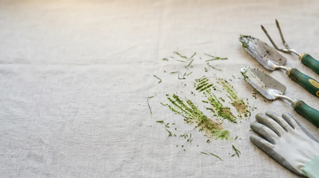 Green grass stains on linen with garden tools and gloves