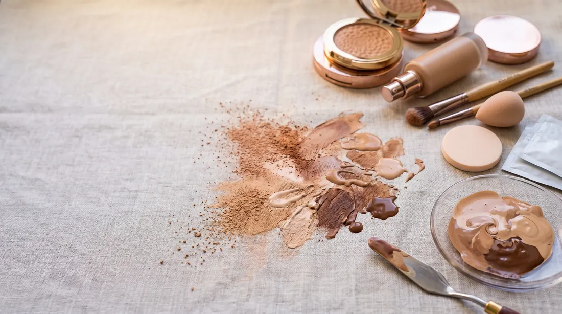 Foundation and powder makeup smeared on linen with compacts and brushes