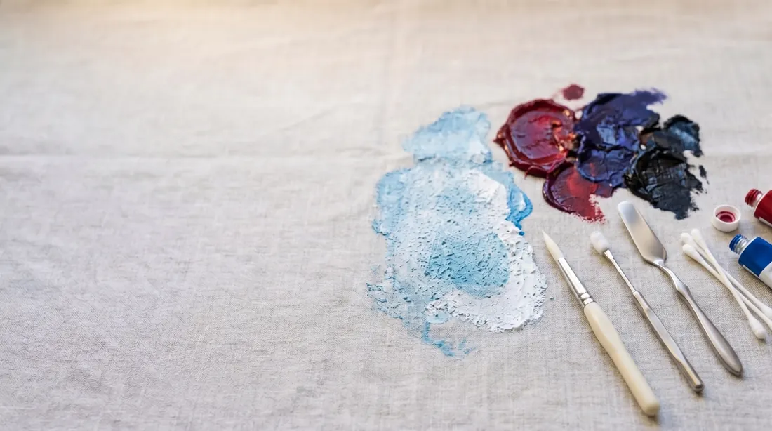 Blue, red and purple paint smeared on linen with brushes and palette knives
